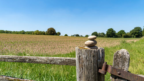 Three balancing stones on top of an old wooden post