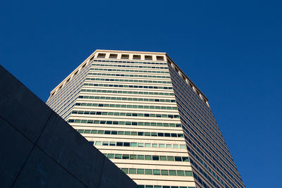 Low angle view of modern building against clear blue sky
