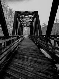 Empty footbridge against sky