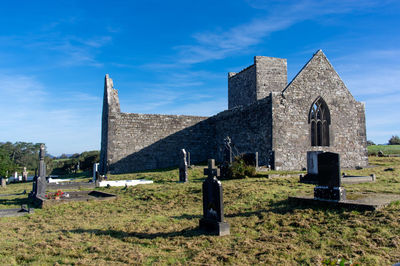 Tombstones in cemetery against sky