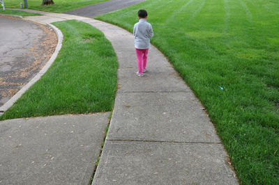 Rear view of girl walking on footpath