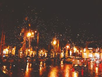 Close-up of wet illuminated city during rainy season