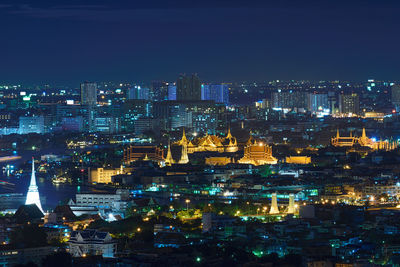 Illuminated cityscape against clear sky at night