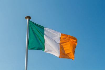 Low angle view of irish flag against clear sky