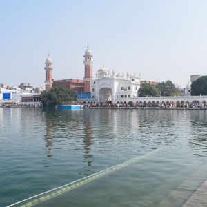 Buildings by river against sky