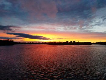 Scenic view of sea against cloudy sky at sunset