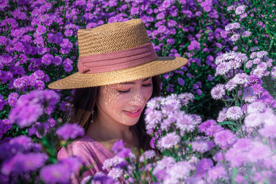 Close-up portrait of woman with purple flowers