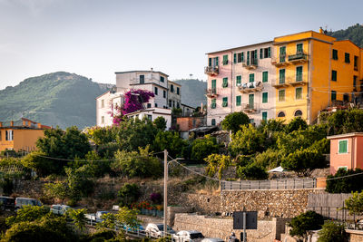 View of colorful apartment buildings on a hill on a sunny day in corniglia, cinque terre, italy