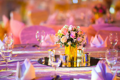 Flower vase on table against glass wall