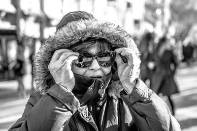 Woman in warm clothing and sunglasses during sunny day