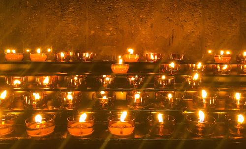 Illuminated candles against buildings