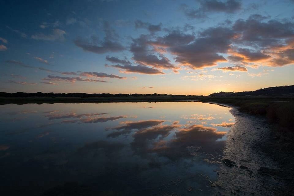 SCENIC VIEW OF CALM LAKE AT SUNSET