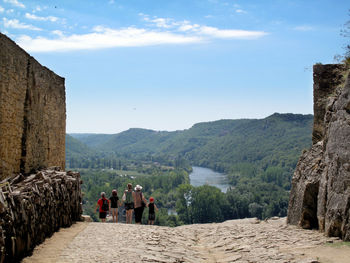 People walking on footpath against mountain