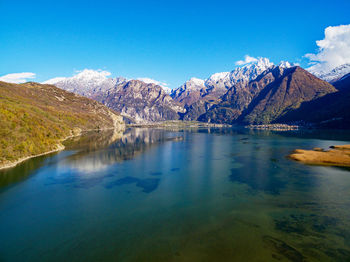 Scenic view of lake and mountains against blue sky