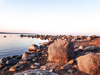 Rocks on beach against clear sky