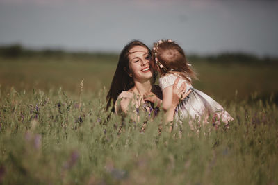 Happy young woman on field against sky