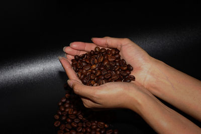 Close-up of hand holding coffee beans