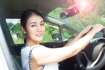 Portrait of smiling young woman in car