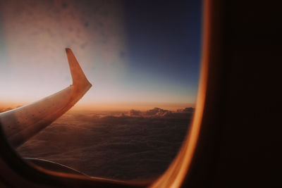 Airplane flying against sky during sunset