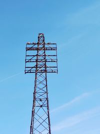 Low angle view of communications tower against blue sky