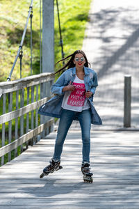 Portrait of young woman standing on railing