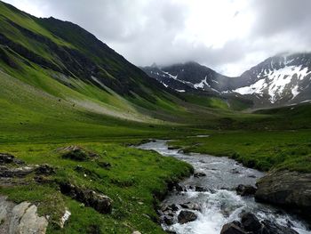 Scenic view of mountains and lake against cloudy sky