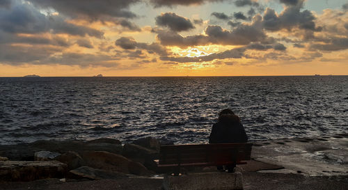 Rear view of man sitting on beach