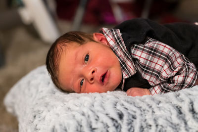 Portrait of cute baby lying on plush pillow