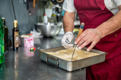 Fourth generation baker cutting gibanica pastry in belgrade, serbia