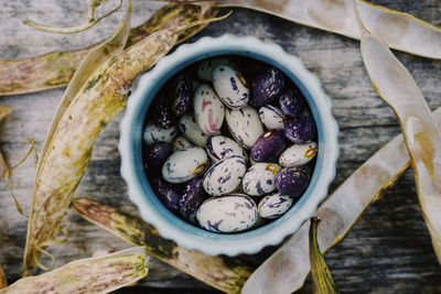 Close-up of beans in container on wooden table