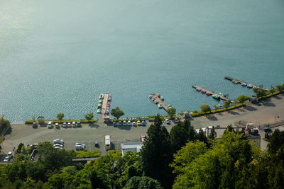 High angle view of plants by sea against city