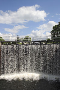 Scenic view of waterfall against sky