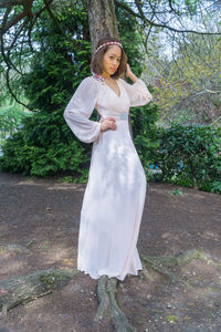 Portrait of young woman standing in park