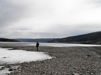 Man standing on beach against sky