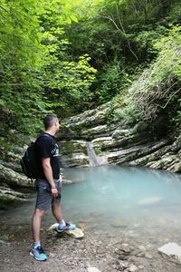 Full length of man standing on footpath in forest