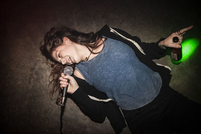 Cheerful woman singing on microphone