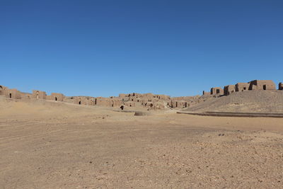 Panoramic view of desert against clear blue sky