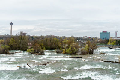 River in city against sky during winter