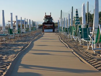 Row of deck chairs on beach against clear sky