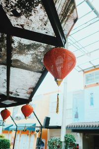 Low angle view of lanterns hanging by building