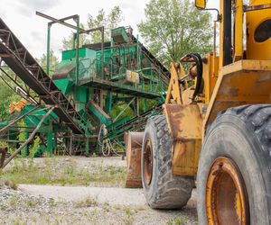 Earth mover at construction site against sky