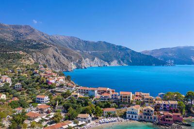 High angle view of townscape by sea against clear sky