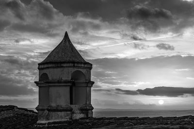 Low angle view of historic building by sea against sky