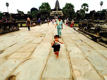 Rear view of people walking on road