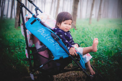 Portrait of cute girl sitting on field