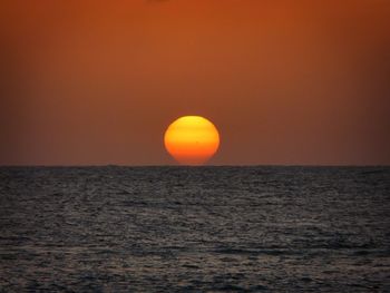 Scenic view of sea against orange sky