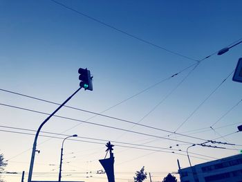 Low angle view of people against clear blue sky