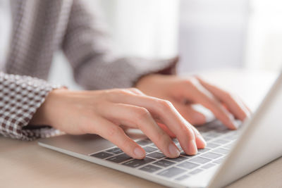 Midsection of woman using laptop on table