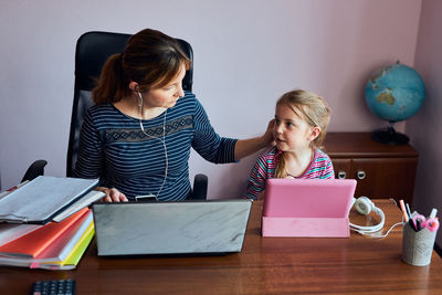 Woman mother working doing her job remotely during video chat call stream online course webinar