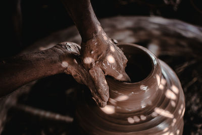 Cropped hands making pottery in workshop